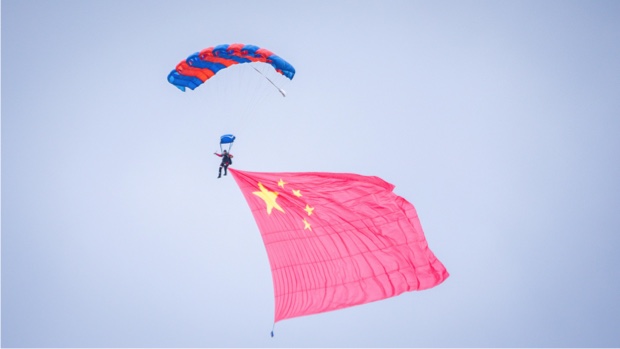 WHA parachute demonstration jumper carrying a large Chinese national flag in flight